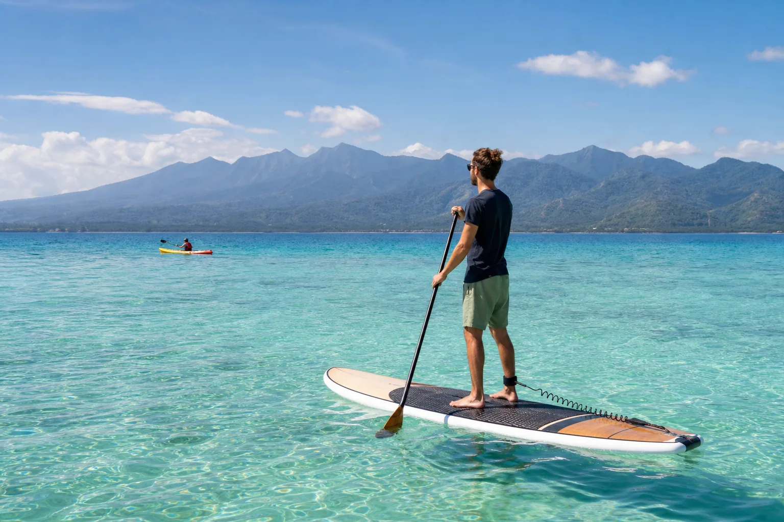 Traveller stand-up paddleboarding in calm water off Gili Air